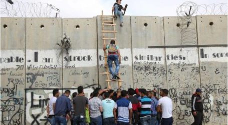 فلسطينيون يتسلقون “جدار الفصل” للصلاة في “الأقصى”